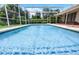 Refreshing screened-in pool with cool blue water is ready for summer relaxation and fun at 900 Howard Nw Ter, Winter Haven, FL 33881