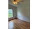 Bright bedroom features wood-look laminate flooring, neutral paint, and ample natural light from the window at 9625 Moore Rd, Lakeland, FL 33809