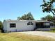Well-maintained single-story home with a cozy porch and gravel driveway on a sunny day at 9625 Moore Rd, Lakeland, FL 33809