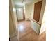 Hallway with hardwood flooring, featuring a storage cabinet, and white door entrance at 9625 Moore Rd, Lakeland, FL 33809
