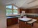 Bright kitchen with vaulted ceiling features white appliances, a double island, and many windows at 9625 Moore Rd, Lakeland, FL 33809
