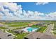 Aerial view of community pool with surrounding neighborhood homes and green space under sunny skies at 3528 Dahlia Dr, Haines City, FL 33844