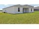 Home showcasing a simple, covered patio area and a spacious, green backyard perfect for outdoor activities at 3528 Dahlia Dr, Haines City, FL 33844