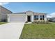 Charming single-story home featuring a two-car garage, well-manicured lawn, and modern architectural details at 3528 Dahlia Dr, Haines City, FL 33844