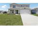 Charming two-story home with a well-maintained lawn and a two car garage at 3508 Dahlia Dr, Haines City, FL 33844