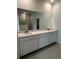 Bathroom with double sink vanity, large mirror, and walk-in shower with marble tile at 6107 Sw 115Th Street Rd, Ocala, FL 34476