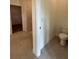 Well-lit bathroom featuring tile floors, toilet and an open doorway to a walk-in shower at 6107 Sw 115Th Street Rd, Ocala, FL 34476