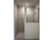 Walk-in shower featuring glass partition and marble tile at 6107 Sw 115Th Street Rd, Ocala, FL 34476