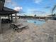 Sparkling community pool with lounge chairs, tables, and umbrellas for relaxation at 2203 Majestic Span Ave, Eagle Lake, FL 33839