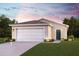 Inviting single-story home featuring a two-car garage, manicured lawn, and a welcoming entryway at 2203 Majestic Span Ave, Eagle Lake, FL 33839