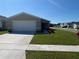 Charming single-story home featuring a well-maintained lawn and a two-car garage at 2374 Aquiline Nest St, Eagle Lake, FL 33839