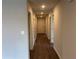 Long hallway with light walls and dark wood-look flooring at 2322 Sw 146Th Loop, Ocala, FL 34473