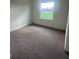 Cozy bedroom with neutral carpet, bright window overlooking outdoors at 10776 Sw 49Th Ave, Ocala, FL 34476
