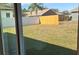 The backyard features a grassy area and a wooden fence at 405 Manitoba Ln, Poinciana, FL 34759