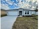 Newly constructed one-story home featuring a two-car garage and well-manicured lawn at 1635 Texas Ave, Sumterville, FL 33585