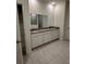 Bathroom featuring double vanity, white cabinets, grey countertop and neutral tiled floors at 5530 Sw 103Rd St Rd, Ocala, FL 34476