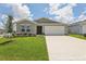 Charming single-story home featuring a two-car garage, well-maintained lawn, and fresh landscaping at 4323 Periwinkle Pl, Lake Hamilton, FL 33851