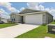 Side view of a single-story home with a two-car garage and a well-manicured lawn at 4323 Periwinkle Pl, Lake Hamilton, FL 33851