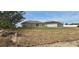 Overgrown backyard with a view of the home's back at 1807 Don Pl, Poinciana, FL 34759