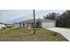 Newly constructed single-story home with a two-car garage and a well-manicured lawn at 1807 Don Pl, Poinciana, FL 34759