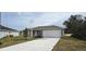 New single-story home with attached garage and landscaped front yard at 1807 Don Pl, Poinciana, FL 34759