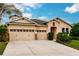 Tan house with three-car garage and neatly landscaped front yard at 30120 Hackney Loop, Mount Dora, FL 32757