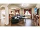 Spacious living area with hardwood floors, a curved sofa, and built-in bookshelves at 30120 Hackney Loop, Mount Dora, FL 32757