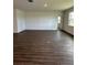 Large living room featuring wood-look tile, natural light, and access to the backyard at 4275 Sw 106Th Pl, Ocala, FL 34476