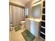 Bathroom with tile floors, shower with curtain, white vanity and black storage at 1223 Lawrence Ave, Deltona, FL 32725