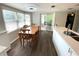 Open dining area with wood floors, view to sliding glass doors and open to kitchen at 1223 Lawrence Ave, Deltona, FL 32725