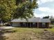 Beautiful brick home with attached garage, manicured lawn, and mature tree providing shade at 1223 Lawrence Ave, Deltona, FL 32725