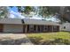 Inviting single-story brick home with a two-car garage and a manicured front lawn at 1223 Lawrence Ave, Deltona, FL 32725