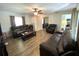 Bright living room boasts laminate flooring, neutral paint, ceiling fan, and comfortable leather seating at 1223 Lawrence Ave, Deltona, FL 32725