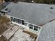 The home's rear exterior with access to a screened enclosure and stone patio at 1223 Lawrence Ave, Deltona, FL 32725