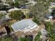 An aerial view of the home's rear exterior with a stone patio and lush green trees at 1223 Lawrence Ave, Deltona, FL 32725
