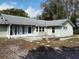 The home's rear exterior features a brick firepit, screened enclosure, and large windows at 1223 Lawrence Ave, Deltona, FL 32725