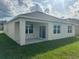Rear exterior view showcasing a covered patio and sliding glass doors to the backyard at 999 Brooklet Dr, Davenport, FL 33837
