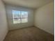Bright bedroom featuring neutral carpet, fresh white paint, and a window providing natural light at 999 Brooklet Dr, Davenport, FL 33837