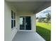 Covered patio with sliding glass doors overlooks the expansive backyard and lush greenery at 999 Brooklet Dr, Davenport, FL 33837