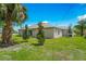 New grass installed in backyard with small trees, and a neutral-colored exterior at 1840 India Palm Dr, Edgewater, FL 32141