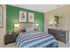 Bedroom featuring a dark green accent wall, modern lamps, and striped bedding at 1840 India Palm Dr, Edgewater, FL 32141