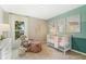 Calming Bedroom features a rocking chair, white crib, and ocean-themed wall art at 1840 India Palm Dr, Edgewater, FL 32141