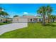 Inviting single-story home with lush lawn, two-car garage, and attractive landscaping at 1840 India Palm Dr, Edgewater, FL 32141