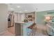 The open-concept kitchen features an island with bar stool seating, stainless steel appliances, and a light color scheme at 1840 India Palm Dr, Edgewater, FL 32141