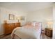 Comfortable bedroom with neutral walls, wood-look floors, and a bed with bright floral patterned bedding at 906 Beechwood Ave, Lady Lake, FL 32159