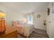 Cozy bedroom featuring neutral walls, wood-look floors, and a comfortable bed with bright floral patterned bedding at 906 Beechwood Ave, Lady Lake, FL 32159