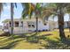Exterior view of home with a deck, front lawn, and tropical landscaping at 906 Beechwood Ave, Lady Lake, FL 32159