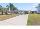Exterior view of home with a long driveway, front lawn, and tropical landscaping at 906 Beechwood Ave, Lady Lake, FL 32159
