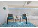 Sunlit covered patio with comfortable seating and a cheerful blue rug at 906 Beechwood Ave, Lady Lake, FL 32159