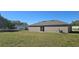 Expansive backyard featuring an AC unit and sliding glass doors, providing ample outdoor space and natural light at 521 Cardinal Dr, Poinciana, FL 34759